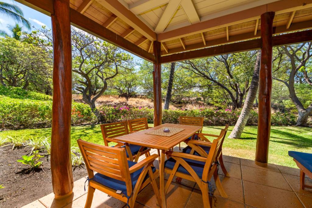 a wooden table and chairs on a porch at Fairways at Mauna Lani #402 in Waikoloa