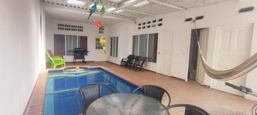 einen Pool in einem Zimmer mit Stühlen und einem Tisch in der Unterkunft Casa Holandesa con piscina privada in Mariquita