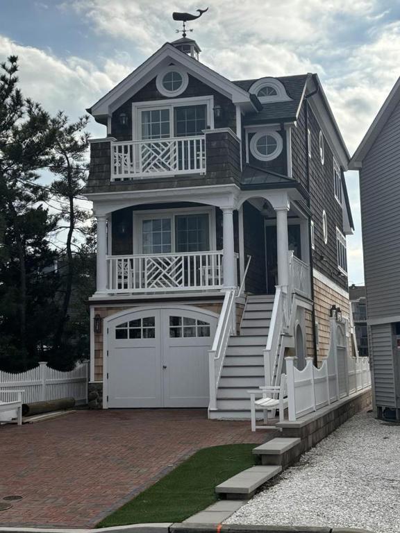 a large house with a porch and a white garage at Beautifully Done 3 Bedroom Single Family Home Close To The Bay In Ship Bottom in Ship Bottom