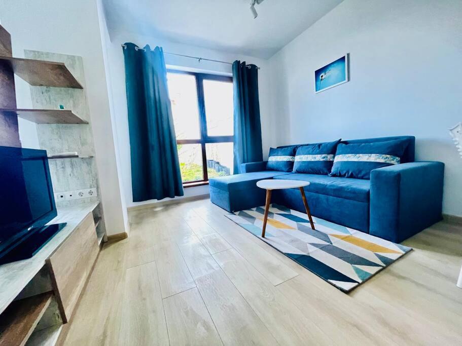 Una sala de estar con un sofá azul y una mesa. en Panoramic Sea View Apartment - Perfect for Couples, en Varna