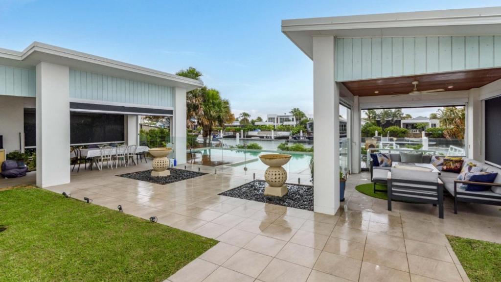 a house with a patio with a view of the water at Luxury & Style On The Canal in Banksia Beach