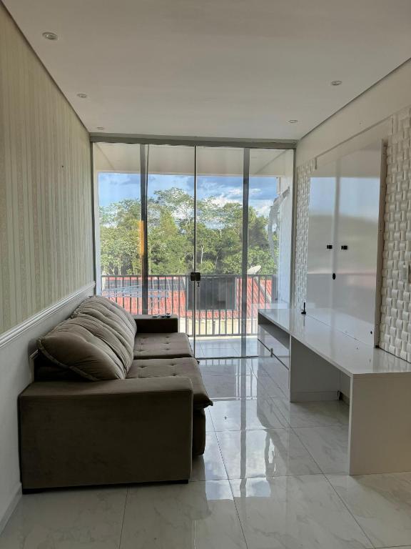 a bedroom with a bed and a desk and windows at LINDO AP no Condomínio Topázio in Rio Branco