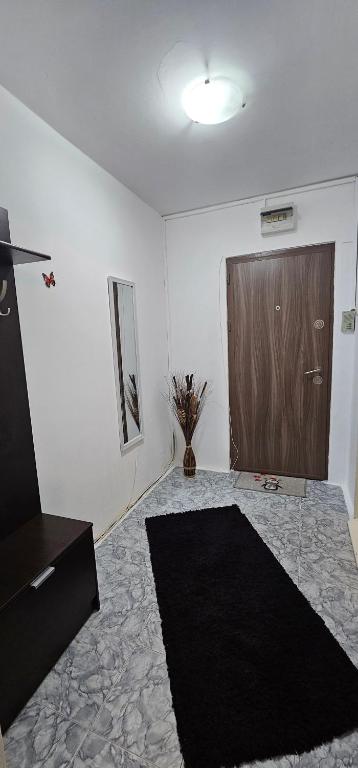 a room with a wooden door and a black rug at Casa Suzana 2 camere in Piatra Neamţ