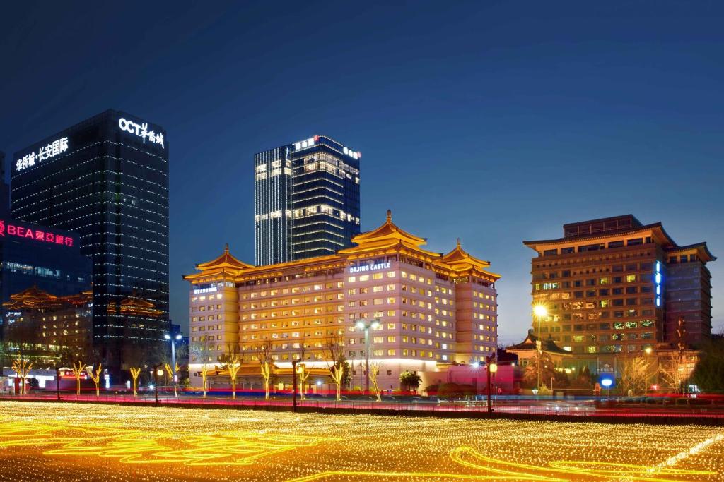 un groupe de bâtiments de nuit dans une ville dans l'établissement Xi'an Dajing Castle Hotel, à Xi'an