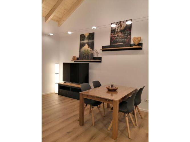 comedor con mesa, sillas y TV en Holiday apartment Rappenfels Lodge, en Hinterweidenthal