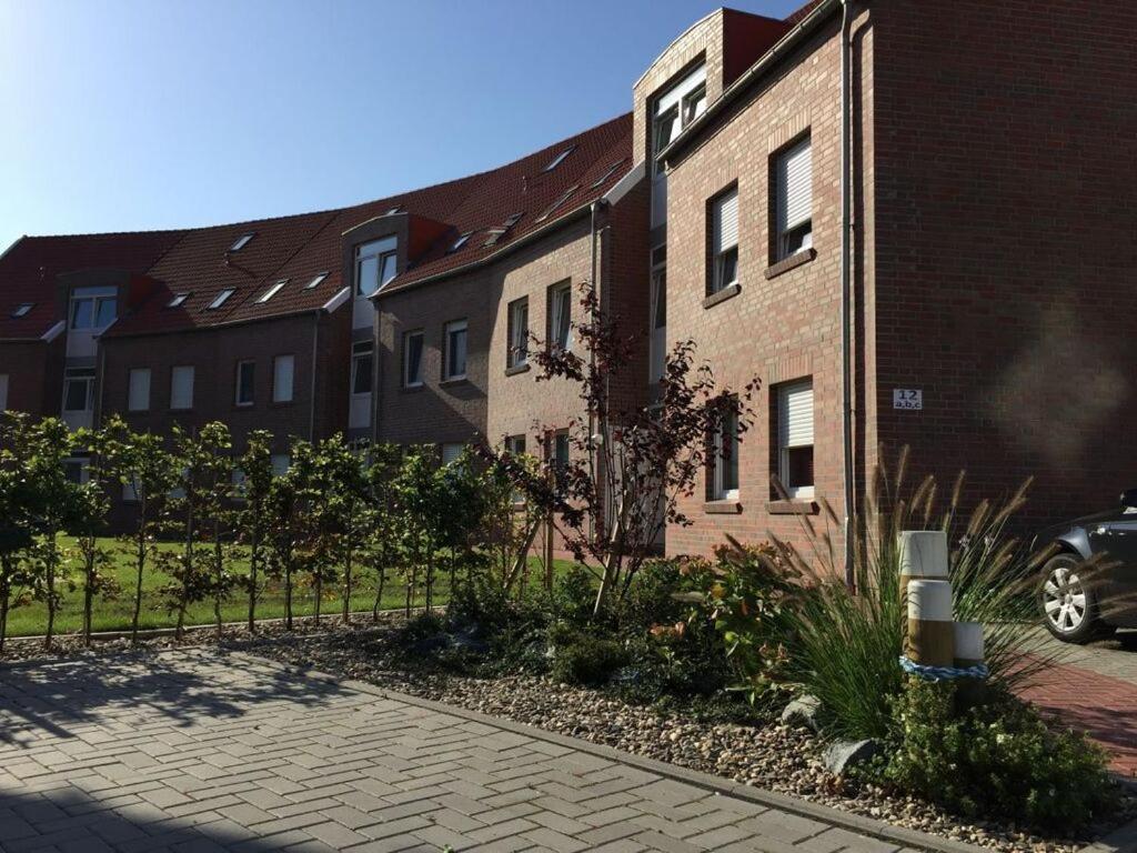 a brick building with a fence in front of it at Nordwind Modern retreat in Norddeich