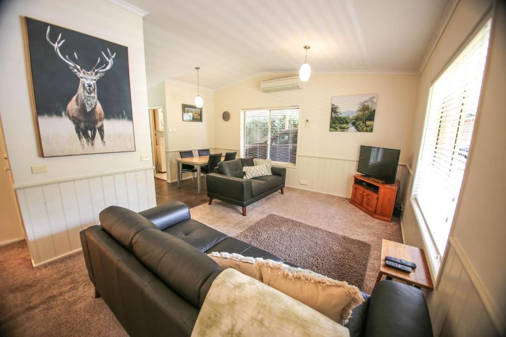 a living room with a couch and a deer on the wall at Silver Birches Holiday Village - Unit 8 in Bright