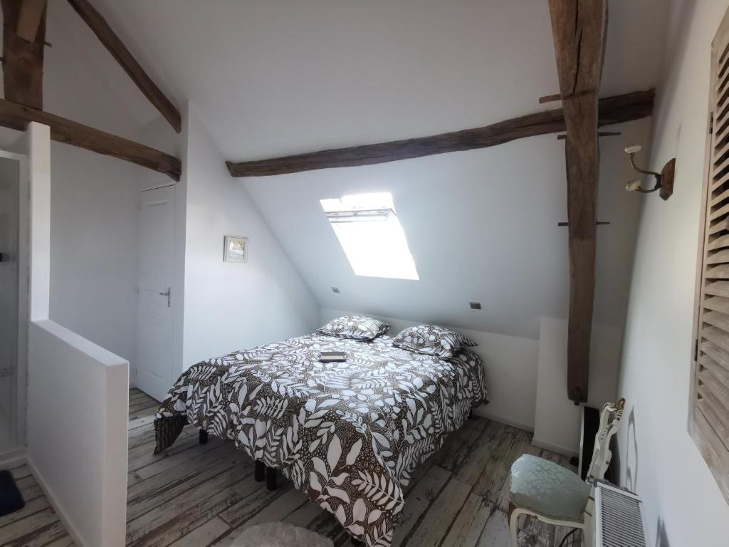 ein kleines Schlafzimmer mit einem Bett im Dachgeschoss in der Unterkunft Le p'tit coin dans les vignes in Restigné