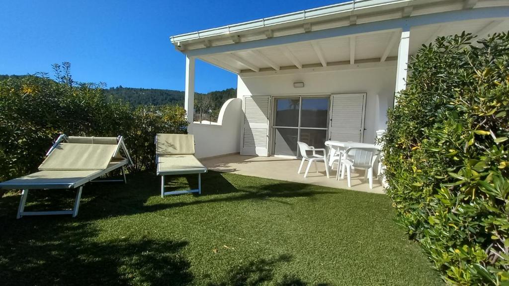 eine Terrasse mit 2 Bänken, einem Tisch und Stühlen in der Unterkunft appartamenti baia di peschici in Peschici