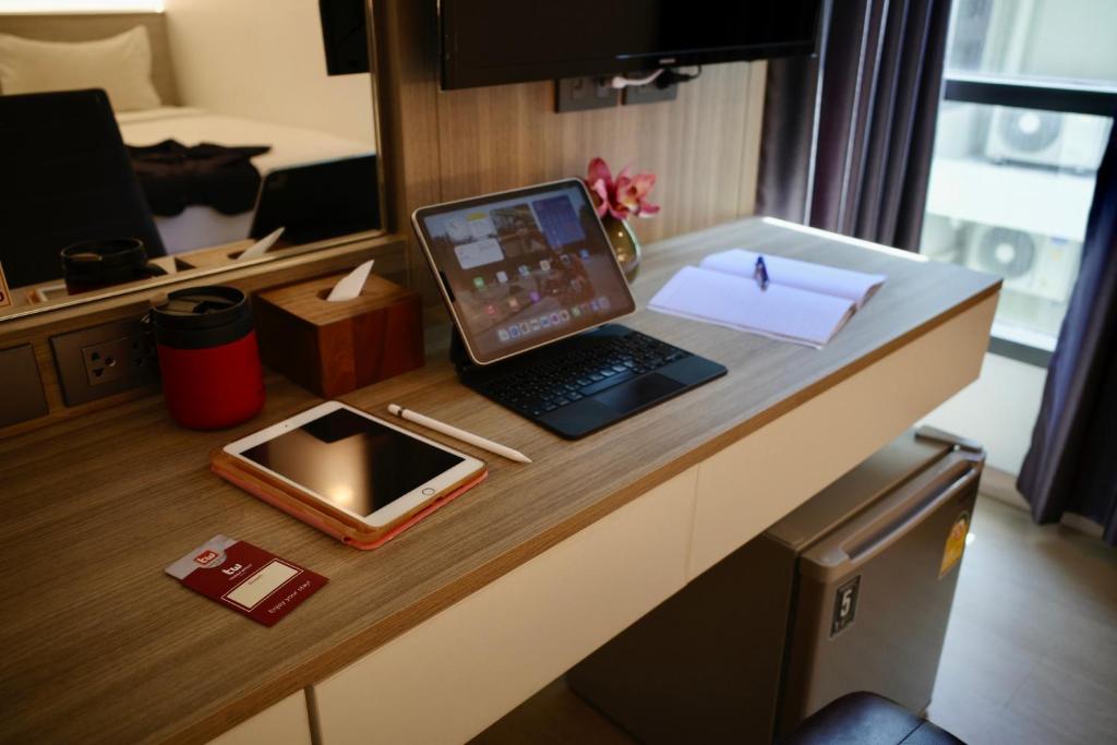 laptopa siedzącego na biurku w pokoju w obiekcie Thana Wisut Hotel - SHA Plus w mieście Bangkok