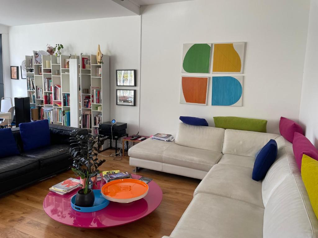 un salon avec un canapé et une table dans l'établissement Guest room in a green setting, à Pantin