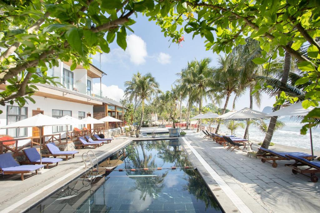 Palm Beach Hotel Phu Yen 1 a pool at the resort with chairs and umbrellas at Palm Beach Hotel Phu Yen - Kite surfing spot in winter in Phú Long (2)