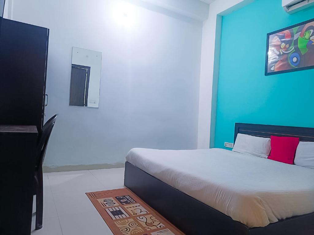 - une chambre avec un lit et un mur bleu dans l'établissement Hotel, à New Delhi