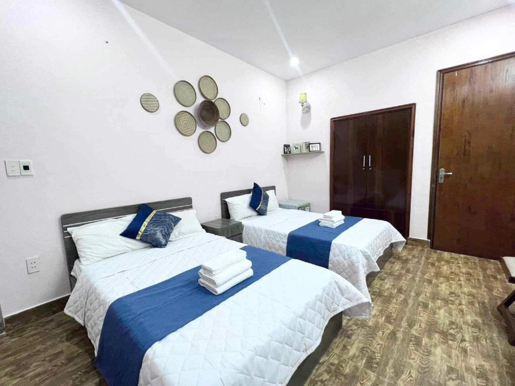 um quarto de hotel com duas camas e um relógio na parede em NA NA Homestay em Ilha de Cát Bà