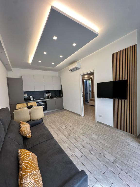 ein großes Wohnzimmer mit einem Sofa und einem TV in der Unterkunft Coho House Fiumicino in Fiumicino