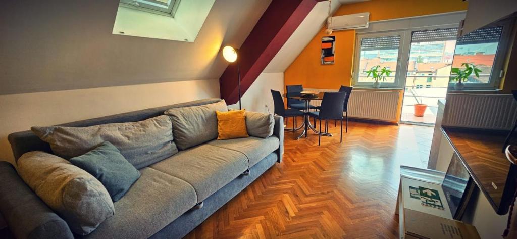 ein Wohnzimmer mit einem Sofa und einem Tisch in der Unterkunft Lega-Cabana Home Osijek in Osijek