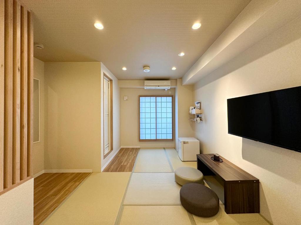 a living room with a flat screen tv on a wall at Osaka Ebisu Hotel in Osaka