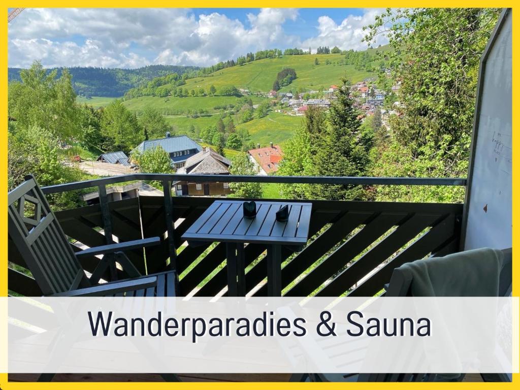 een balkon met een tafel en uitzicht op de bergen bij Fewo Herzgrün mit Balkon und Traumblick direkt an Wanderwegen und Sauna im Haus in Todtnauberg