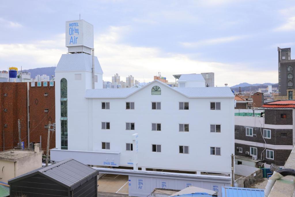 um edifício branco com uma torre de relógio em cima em Aank Air Hotel Daejeon em Geochang