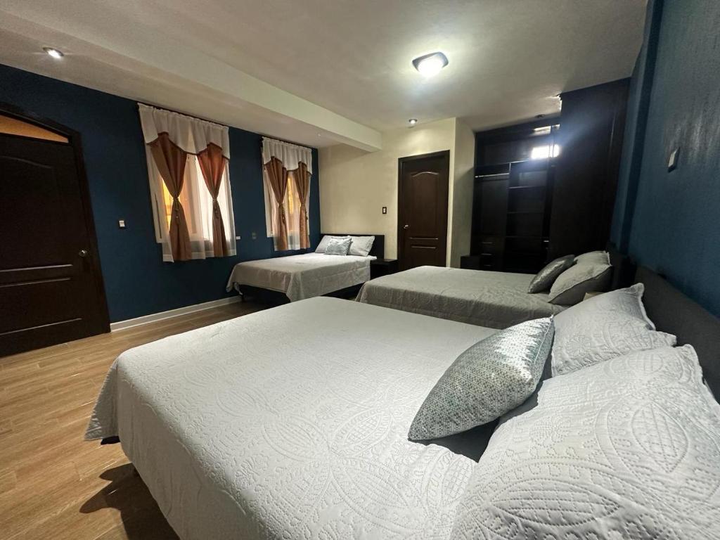 pokój hotelowy z 2 łóżkami i niebieskimi ścianami w obiekcie CASA DE DESCANSO TZANJAAY w mieście San Juan La Laguna