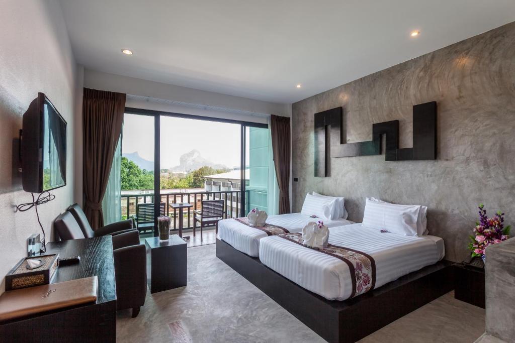 a hotel room with a large bed and a balcony at Aonang Viva Resort - SHA Plus in Ao Nang Beach