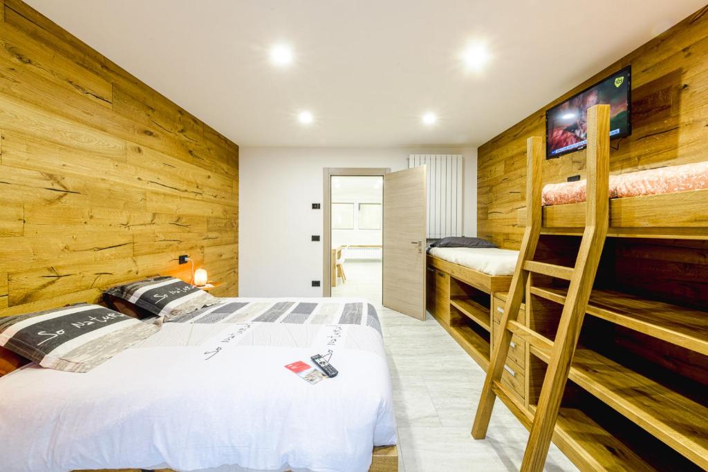 a bedroom with a bed and two bunk beds at Appartamento San Carlo in Tirano