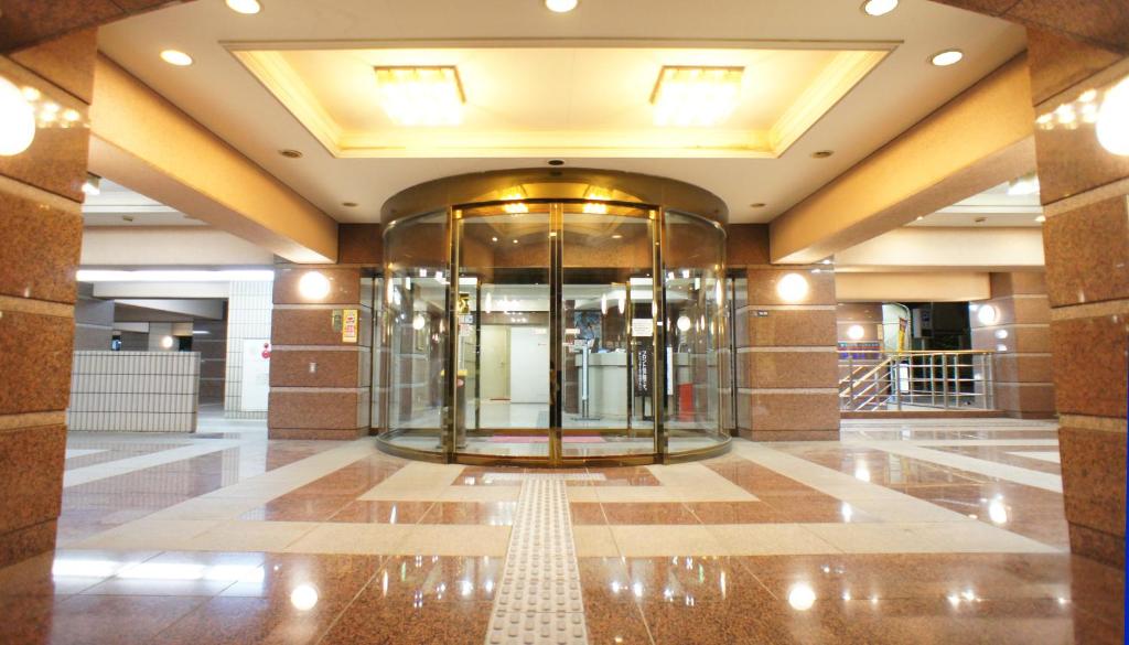 川崎的住宿－柯麗格亞廣場酒店，大楼内带玻璃电梯的大堂