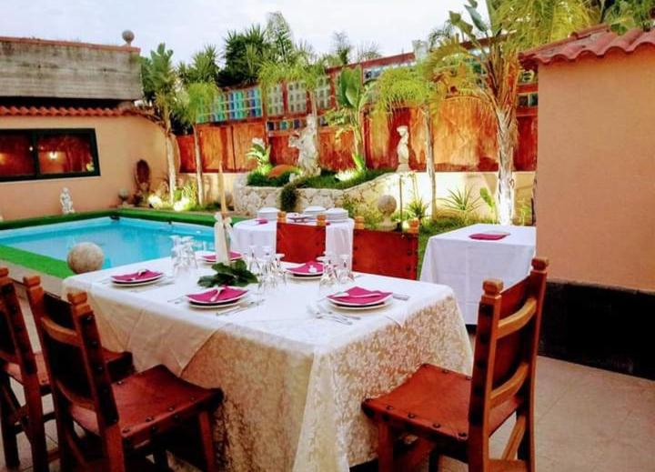 - une table avec une nappe et des chaises blanches à côté de la piscine dans l'établissement Villa Courrier, à Tremestieri Etneo