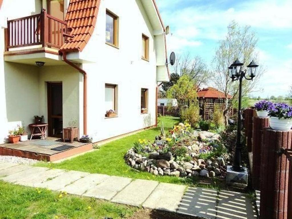 een tuin voor een wit huis bij Ferienwohnung in Rewal mit Garten und Grill in Rewal