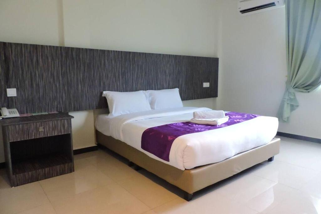 a bedroom with a large bed with a wooden headboard at Salsa Resort Langkawi By Casa Loma in Pantai Cenang
