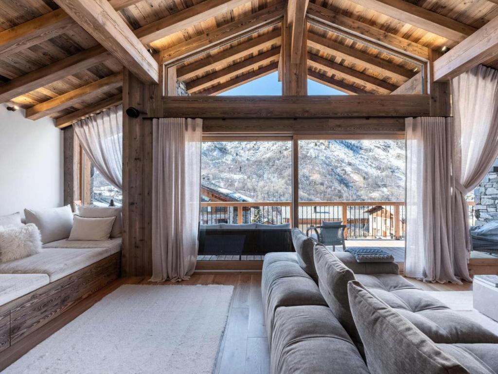 - un salon avec un canapé et une grande fenêtre dans l'établissement Chalet Marcel - Chalets pour 12 Personnes 691, à Saint-Marcel