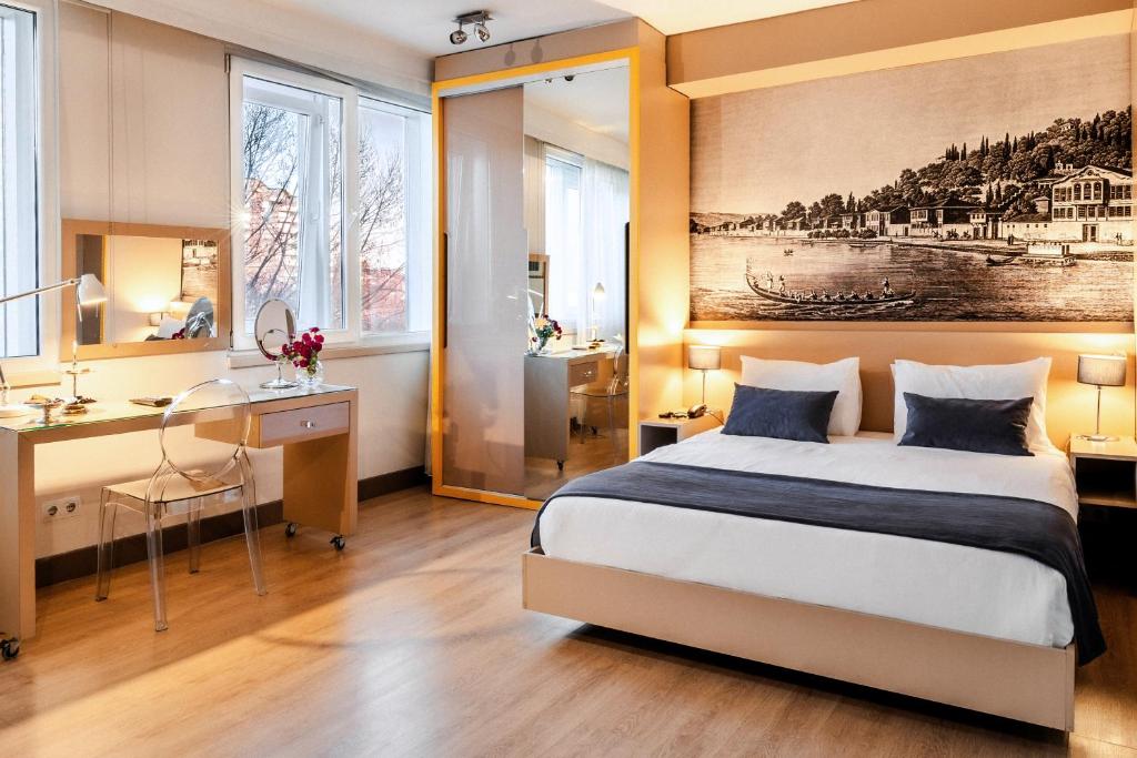 a bedroom with a bed and a desk and a mirror at Cheya Beşiktaş Istanbul Bosphorus City Center Hotel & Suites in Istanbul
