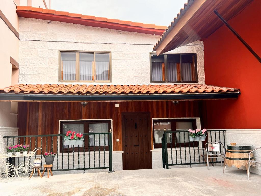 een huis met een veranda met stoelen en een hek bij La casita de la abuela in Villarcayo