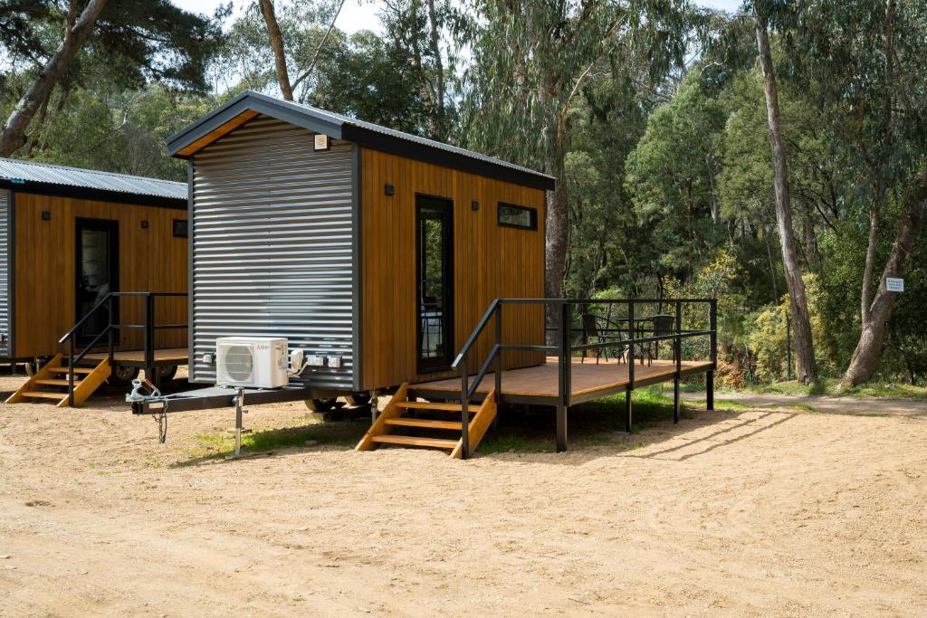 a small cabin with a porch and stairs to it at Bright Cabin Park in Bright