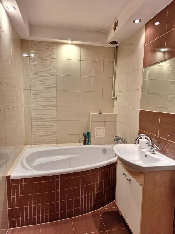 La salle de bains est pourvue d'une grande baignoire et d'un lavabo. dans l'établissement Apartament Stalowa Wola centrum, à Stalowa Wola