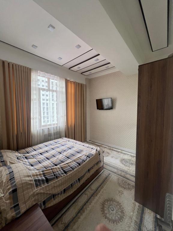 a bedroom with a bed and a window at Dom Shohon in Dushanbe