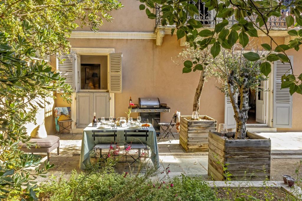 un patio con tavolo, sedie e griglia di Villa les Roses a Brando