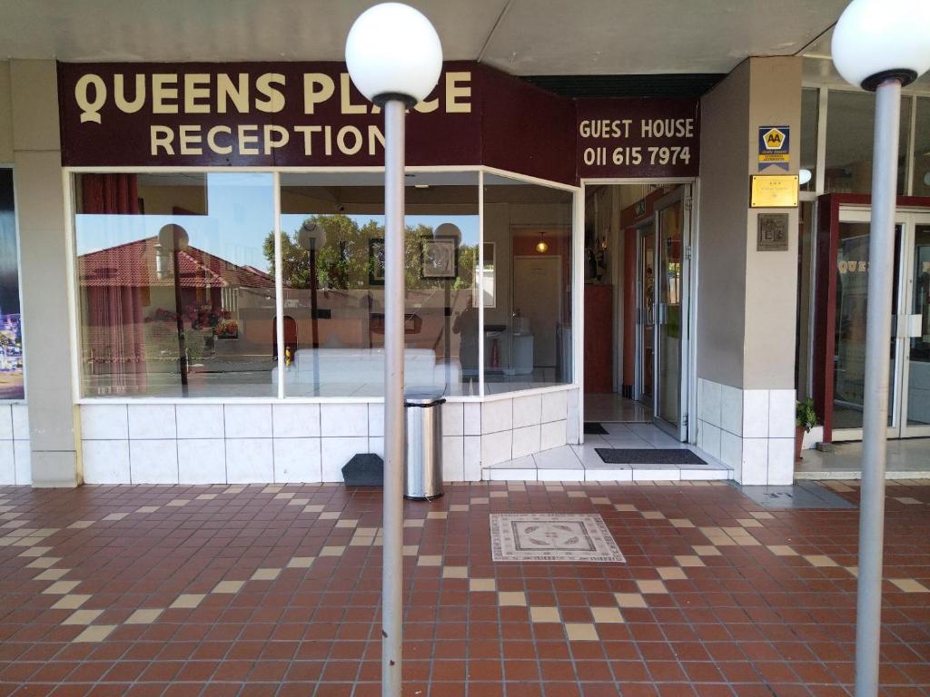 ein Gebäude mit zwei Straßenbeleuchtung davor in der Unterkunft Queen's Place in Johannesburg