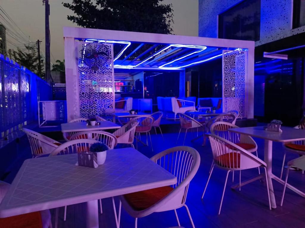 un restaurante con mesas, sillas y luces azules en Jada Lifestyle & Lounge, en Lagos