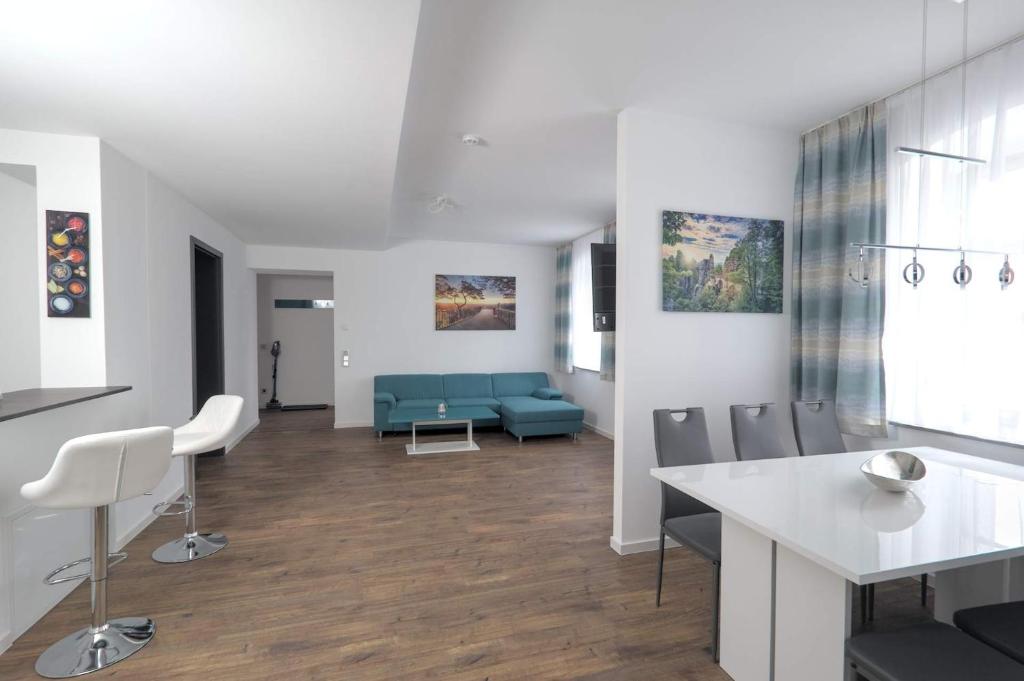 a living room with a blue couch and chairs at Ferienquartier- Forsthaus in Bad Gottleuba