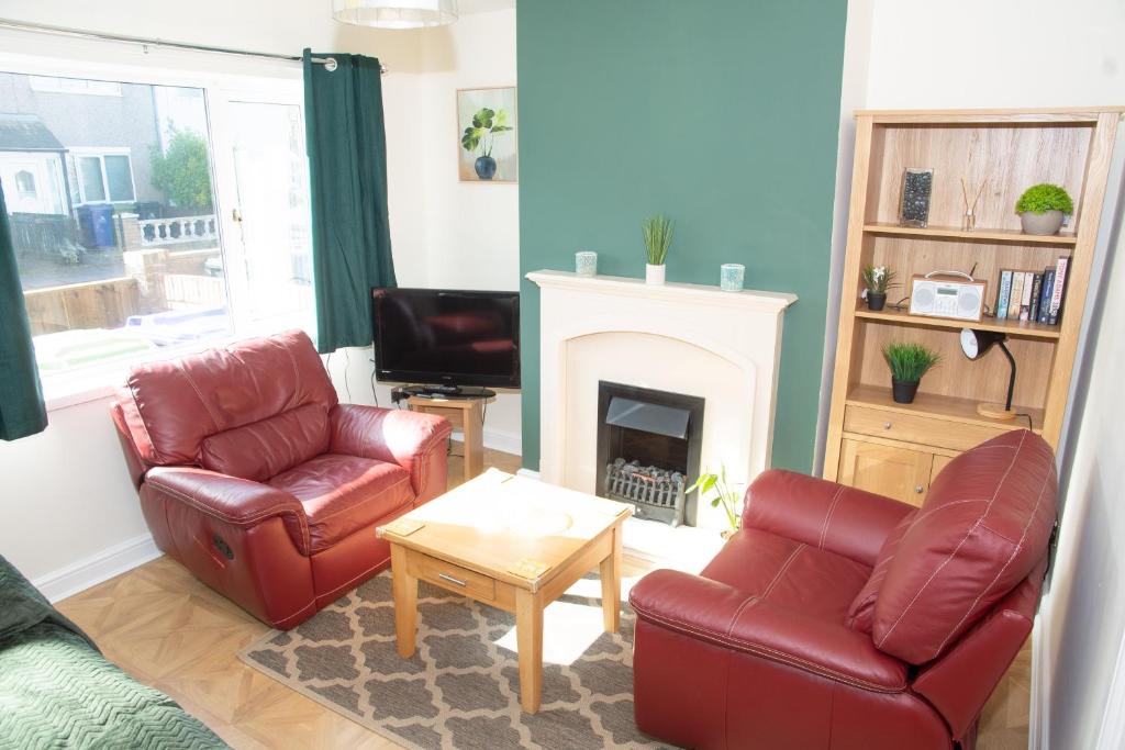 a living room with two chairs and a fireplace at Lily's Place in Cleethorpes