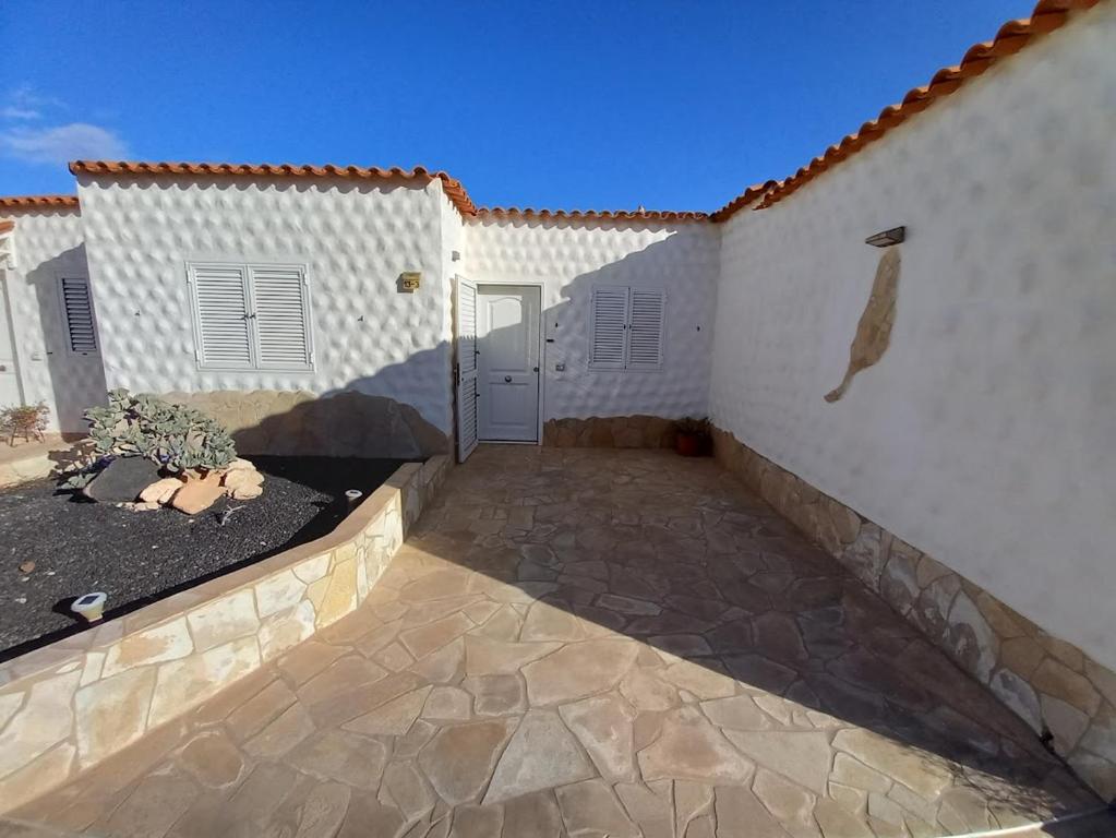 a courtyard of a white building with a door at casa yamila in Costa Calma