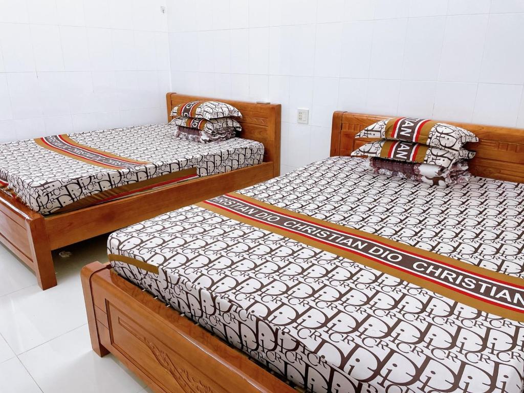 three wooden beds in a room with at Nhà Trọ Số 2 in áº¤p VÄ©nh ÃÃ´ng