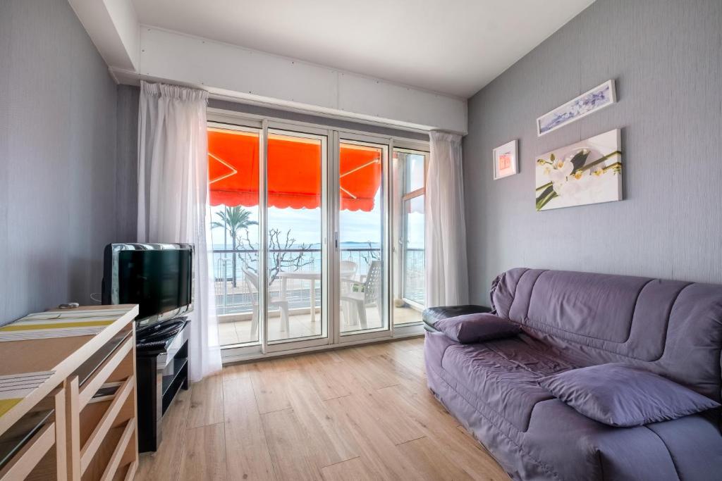 un salon avec un canapé et une grande fenêtre dans l'établissement Angelina - La002, à Cagnes-sur-Mer