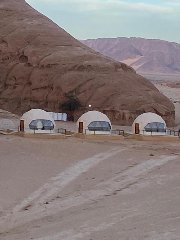 two domes in the desert with a mountain in the background at RAMA CAMP wadi rum in Disah
