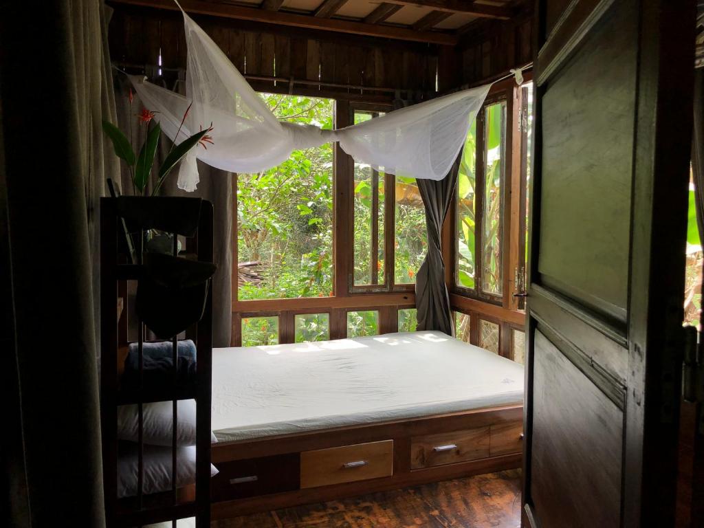 łóżko w pokoju z oknem w obiekcie Tini Wood House w mieście Hue
