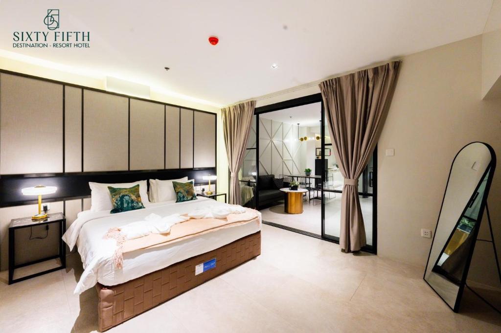 SixtyFifth Destination Resort Hotel في باكولود: غرفة نوم كبيرة مع سرير كبير وغرفة معيشة