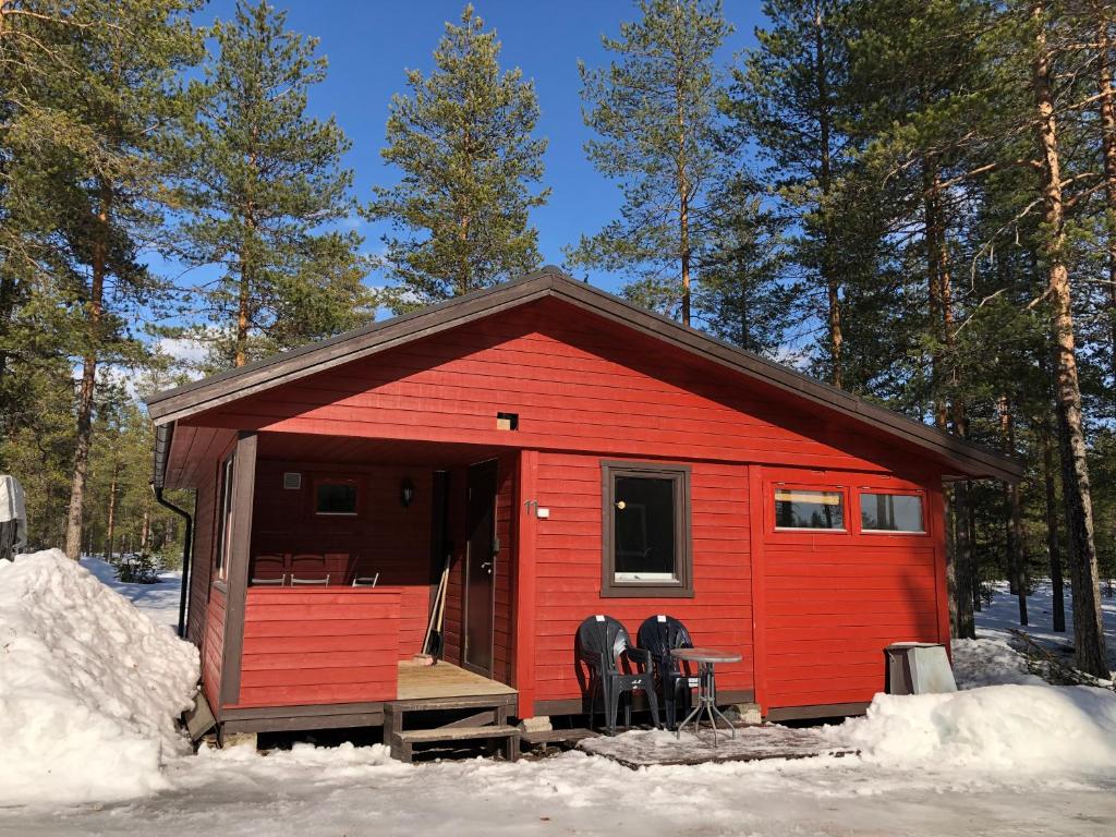 une cabine rouge avec une table et des chaises dans la neige dans l'établissement Rena Hostel IVAR, à Rena