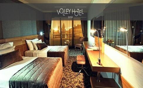 Pokój hotelowy z 2 łóżkami i biurkiem w obiekcie Volley Hotel İzmir w mieście Konak