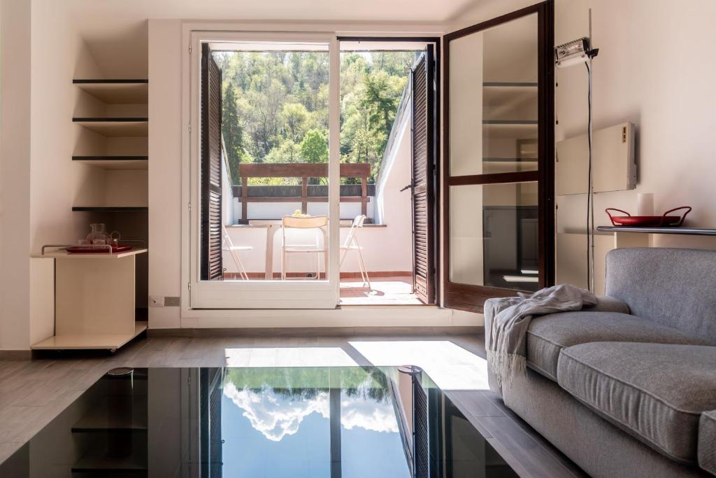 ein Wohnzimmer mit einem Sofa und einem Glastisch in der Unterkunft Casa Balbianella - by LoveComo in Lenno